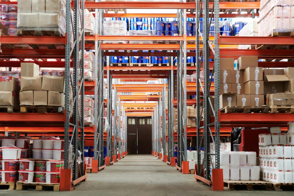 Wide angle view of a warehouse with stocked shelves and boxes.