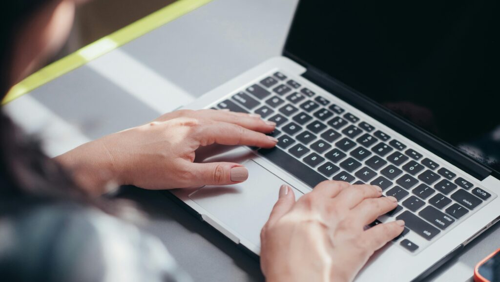 Focused view of a person typing on a laptop, showcasing productivity and technology.